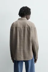 Camisa marrón claro de lino y viscosa, corte holgado, manga larga con puños abotonados y cierre frontal con botones.