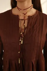 Blusa color chocolate de lino con cuello redondo y lazo ajustable.