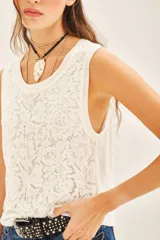 Musculosa blanca de encaje con cuello redondo.