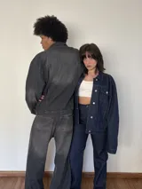 Campera de jean gris oscuro con bolsillos frontales y cierre con botones.