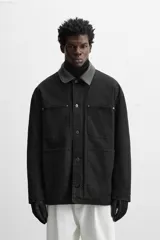 Parka negra de algodón con cuello solapa de cuero sintético, corte recto, acolchada y con cierre frontal de botones.