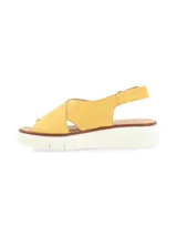 Sandalia amarilla de cuero con tiras cruzadas, suela de plataforma blanca y hebilla metálica de ajuste.