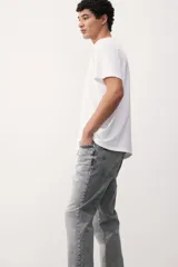 Jean gris de cinco bolsillos en denim de algodón elástico con cintura estándar y cierre con botón. Piernas rectas con buena libertad de movimiento en muslo y rodilla.
