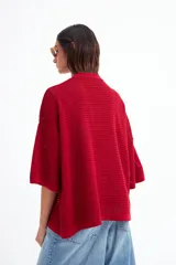 Kimono de tejido de punto calado color rojo, con mangas 3/4 amplias y corte holgado.