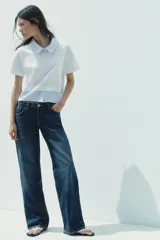 Camiseta blanca de cuello redondo con solapa combinada a contraste de rayas celestes. Manga corta. Bajo con tejido combinado de rayas celestes. Cierre en espalda con abertura y botón.