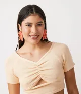 Blusa cropped color crema de viscosa con manga corta, escote en V, fruncido en el busto y abertura en el abdomen.