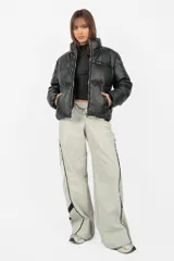 Pantalón deportivo gris de nylon, de calce recto y tiro medio, con elástico en la cintura, cordones ajustables y detalle de recorte con vivo a contratono en los laterales.
