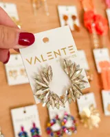 Aretes tipo argolla o ear cuff, con forma de media luna o abanico, compuestos por múltiples cristales facetados transparentes y algunos cristales pequeños de color verde pálido, engastados en una base metálica dorada.