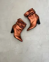 Botines dorados de cuero vacuno con punta fina y tacón aguja.