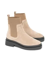 Bota Chelsea de gamuza color beige con elásticos laterales al tono y suela track negra.