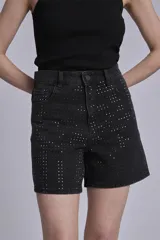 Bermuda de jean negro con tachas plateadas.