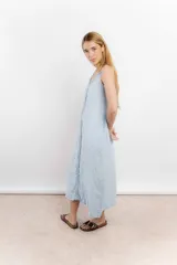 Vestido largo de lino color blanco, con breteles finos y detalle de costura o aplique vertical en el centro del frente.