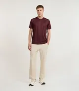 Remera deportiva de manga corta y cuello redondo, color beige claro, con textura acanalada vertical. Presenta detalles reflectantes en los hombros.