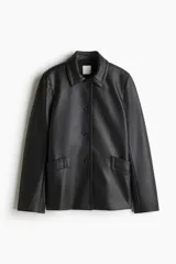 Campera negra de cuero sintético con cuello clásico, cierre frontal con botones, hombreras, bolsillos delanteros con solapa y puños con abertura y botón.
