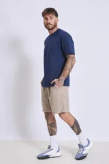 Bermuda color beige confeccionada en lino, con bolsillos laterales y traseros.