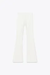 Pantalón blanco de tiro alto, corte ajustado en la pierna y acampanado en el ruedo.