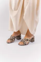 Sandalia tipo zueco de charol rojo con hebilla dorada y taco cuadrado.