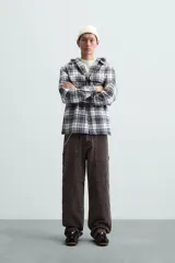 Sobrecamisa de hombre a cuadros azul marino y blanco, corte relaxed fit, con capucha gris de algodón, cuello solapa, manga larga con puños abotonados, bolsillos de parche en el pecho y bolsillos laterales en la cadera.