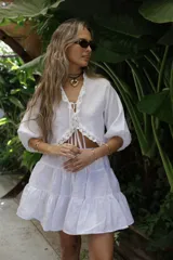 Blusa color beige de lino con puntilla de algodón en el escote y mangas abullonadas con elástico en los puños.