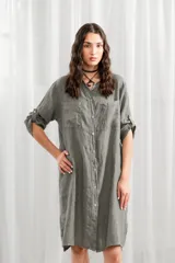 Túnica blanca de lino, corte holgado, con cuello mao, cierre frontal con botones y mangas largas con trabillas para enrollar.