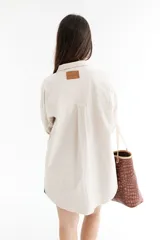 Bolso tipo tote de cuero marrón con textura de cocodrilo, doble asa corta y cierre superior.