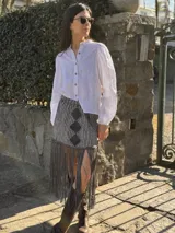 Camisa blanca de lino con cuello mao, mangas largas abullonadas y cierre frontal con botones.