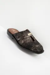 Zuecos con estampado animal print en blanco y negro, con tira ancha de cuero negro y aplique metálico.