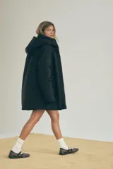 Anorak negro resistente al agua y al viento con aislamiento térmico, cuello alto con capucha ajustable, mangas largas con puño interior de neopreno, tirantes elásticos interiores, bolsillos delanteros con forro polar y cierre de cremallera, bolsillo interior con cremallera oculta y cierre frontal con cremallera termosellada.