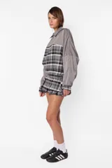 Mini falda gris con estampado de cuadros escoceses, cintura ancha, tablas en la parte inferior y cierre metálico lateral.