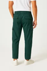 Pantalón cargo negro de corte holgado, con cintura elástica ajustable con cordón, bolsillos laterales y bolsillos tipo parche con solapa en los muslos.