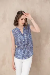 Camisa sin mangas de tejido ligero con estampado colorido en azul, con botones frontales.