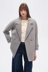 Tapado de poliéster color gris con cuello de solapa y cierre frontal de botones. Cuenta con mangas largas y un diseño de corte recto.