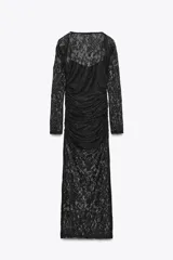 Vestido midi semitransparente de encaje negro, con escote recto, tirantes finos elásticos y mangas largas. Diseño drapeado en los laterales.