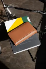 Billetera de cuero vacuno color marrón con cierre perimetral. Se abre completamente como un libro y cuenta con múltiples espacios para tarjetas, billetes y un monedero con cierre incorporado.