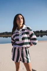Conjunto de short y remera a rayas horizontales color rosa y verde oscuro. La remera es de corte holgado, con cuello polo blanco y botones. El short es de tiro alto con cintura elastizada y cordón ajustable.