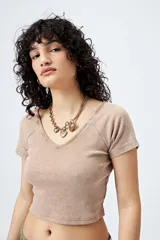 Top blanco de algodón con mezcla de poliéster y elastano, con escote en V delantero y trasero.