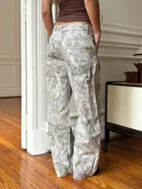 Pantalón baggy gris con estampado abstracto en tonos beige y blanco.