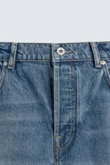 Pantalón de jean celeste de corte recto, con cinco bolsillos y cierre frontal con botones.