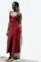 Vestido midi de lino color borgoña, con escote en pico, tirantes finos ajustables, botones frontales y abertura en el ruedo.