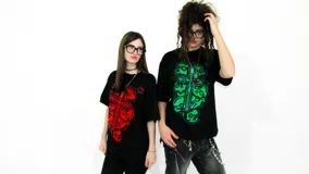 Remera negra de corte regular fit, con estampa roja de una cruz formada por calaveras y una estrella.