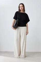 Blusa negra con textura amasada, de mangas cortas y corte holgado.