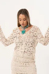 Saco color crudo de crochet con botones y mangas largas.