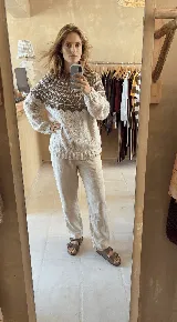 Sweater de lana merino tejido a mano, color negro con diseño geométrico en el canesú en tonos blanco y gris. Presenta cuello redondo, mangas largas y terminaciones acanaladas.