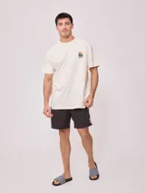 Remera color crudo de algodón con estampa en la espalda con motivos playeros y la frase "Surf Island Rusty Go".