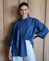 Camisa celeste de mangas largas con cuello clásico y cierre frontal con botones.