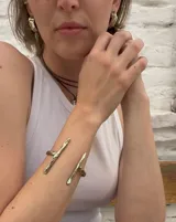 Brazalete abierto de bronce con forma de rama.