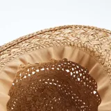 Sombrero de paja color natural con ala ancha y cinta blanca decorativa.