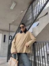 Campera de pana color beige con cierre frontal y cuello negro.