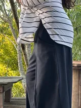 Remerón negro de manga larga, corte oversize con espalda más larga, tajos laterales y bajo redondeado.