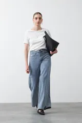 Remera de manga corta color beige claro, confeccionada en tejido acanalado elástico, con cuello redondo.